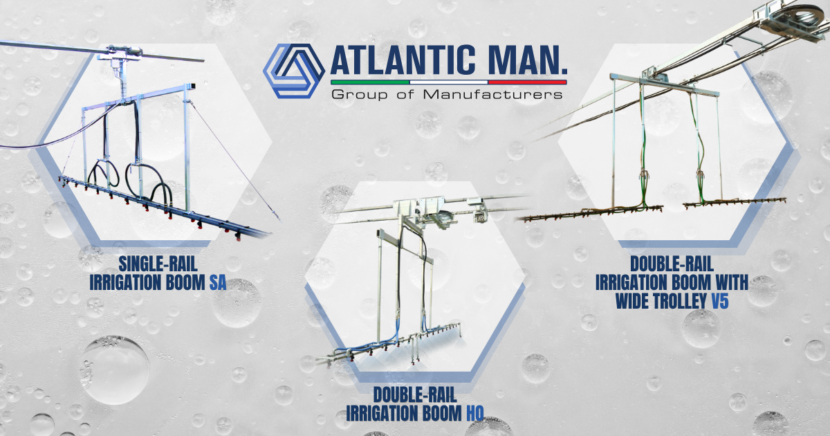 Three Atlantic Man. irrigation booms watering seedling trays inside a greenhouse
